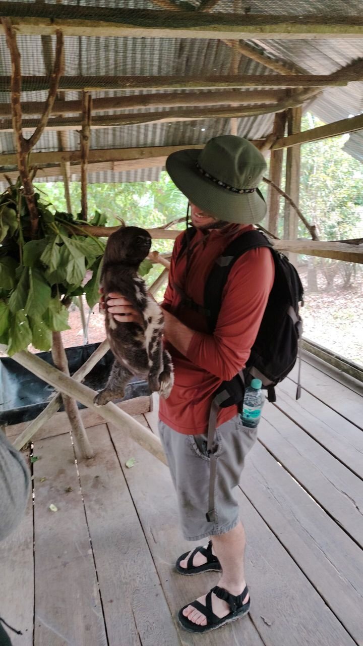 Amazon Camp Tours — turista con perezoso